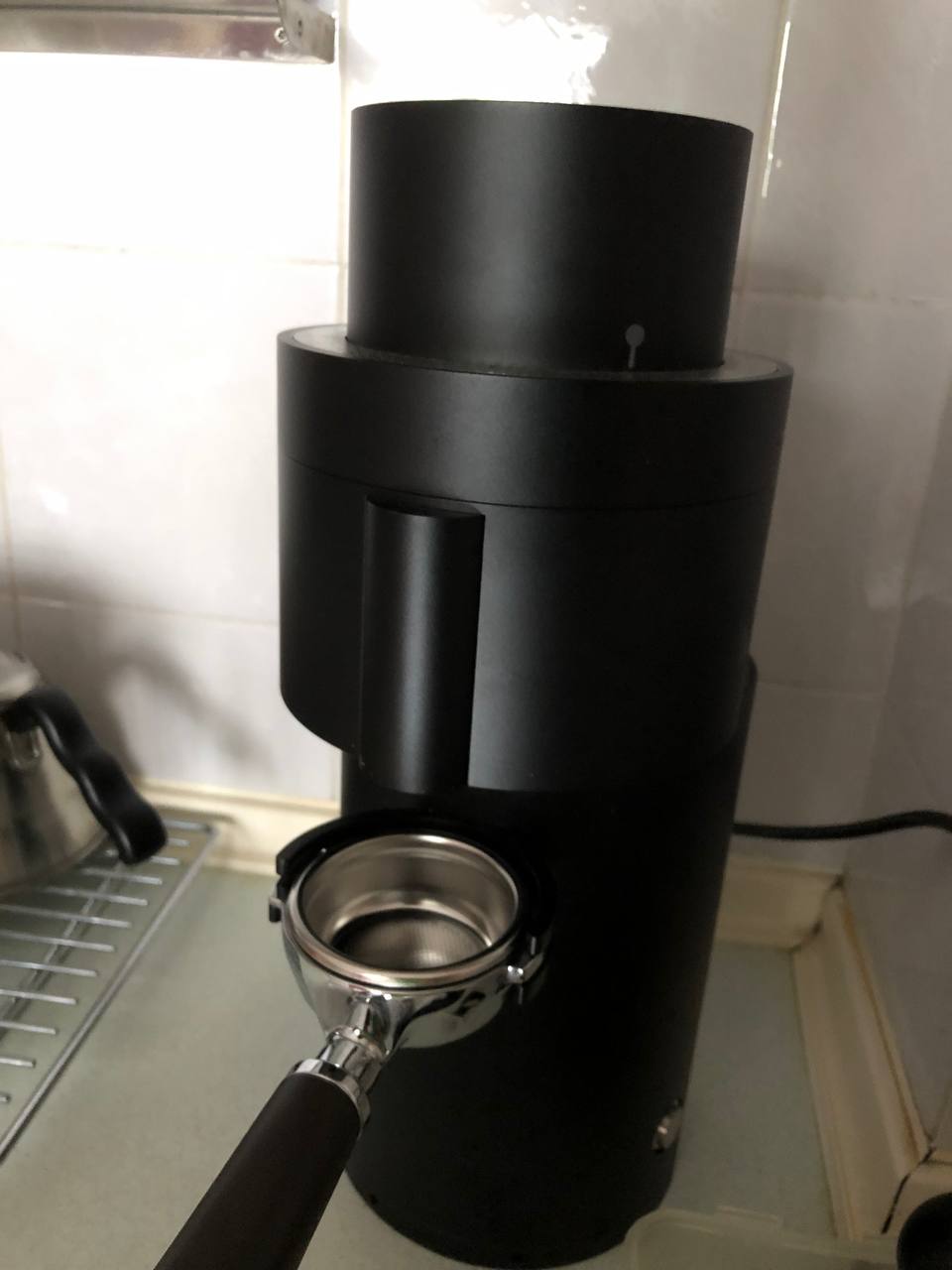 The P100 with an empty portafilter mounted onto the integrated portafilter fork. The 2 ears on each side of the portafilter are set between the prongs of the fork to hold them in place.